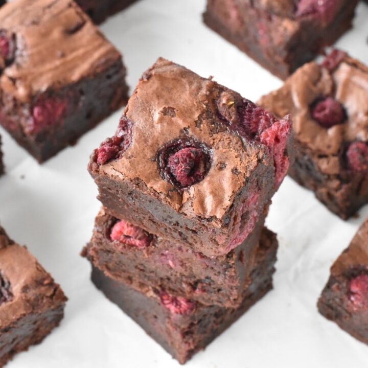 Stack of three raspberry brownie squares.
