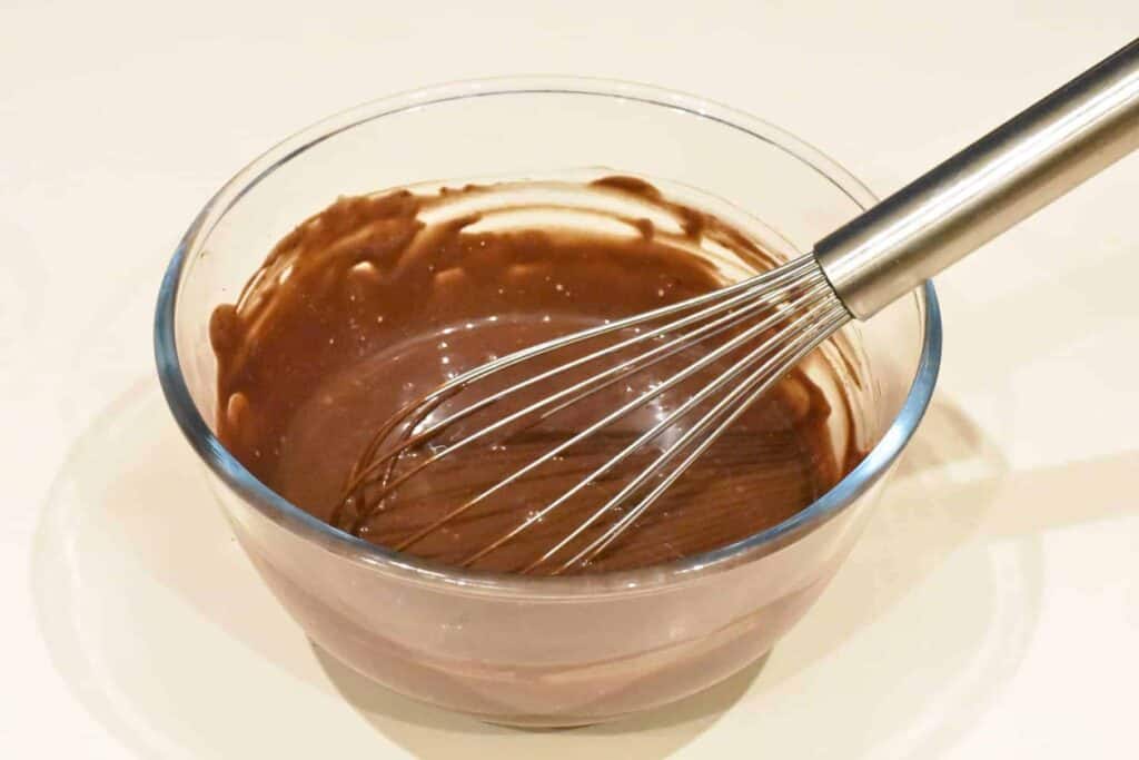 Heated chocolate filling whisked in a bowl.