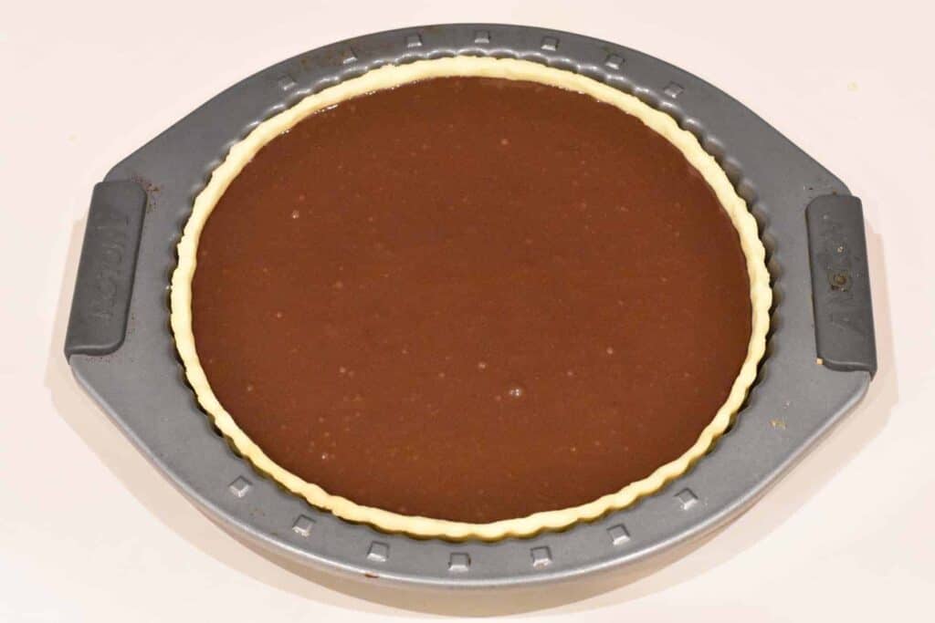 Chocolate filling poured over raspberry layer in tart shell.