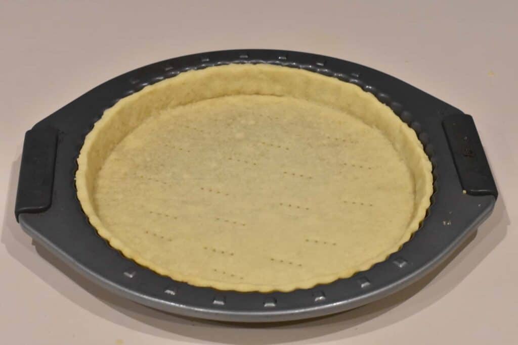 Baked tart shell in tart pan.