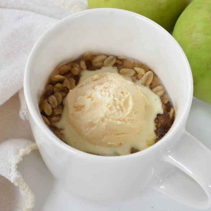 Apple crisp in mug with ice cream.