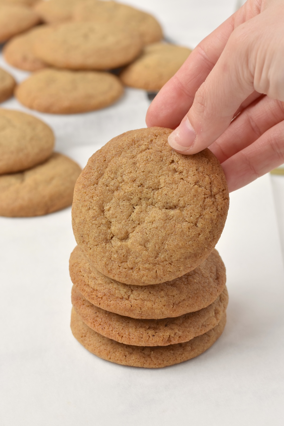 Hand picking up one cookie off a stack.